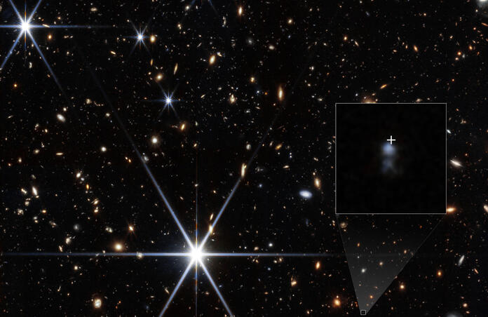 Deep James Webb Space Telescope near-infrared view of the sky field containing the host of fast radio burst FRB 20240304B, with an inset zoom showing the faint, clumpy dwarf host galaxy marked by a white cross. Credit: NASA / ESA / CSA / STScI / Themiya Nanayakkara (University of Sydney) / Joseph DePasquale (STScI).